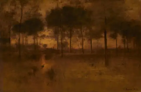 A marsh at dusk in warm amber light, with thin trees and a heron at the water's edge.